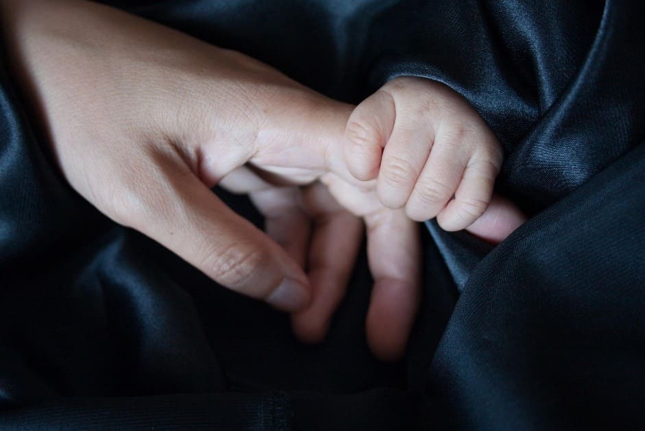 imagen de la mano de un bebe con la mano de su padres